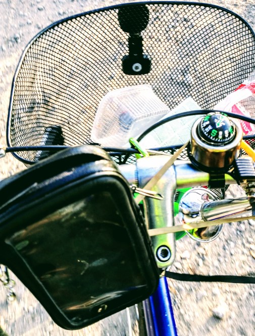 The handlebar of the bicycle with phone older, compass-bell and basket